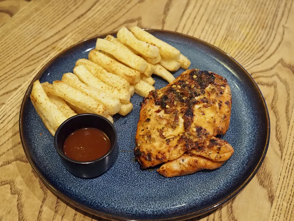 ピリピリチキンの実写写真（現行の国際様式（スパチコック/炭火焼きの半身に赤いピリピリソースを添える・retornados〜Nando's期に確立した現行形）。撮影は英国の店だが盛付けは現行ピリピリチキンの標準形。起源説は諸説併記(モザンビーク植民地/脱植民地化後本国確立)・確度C＝中立な完成皿に留め起源譚を補強しない。）
