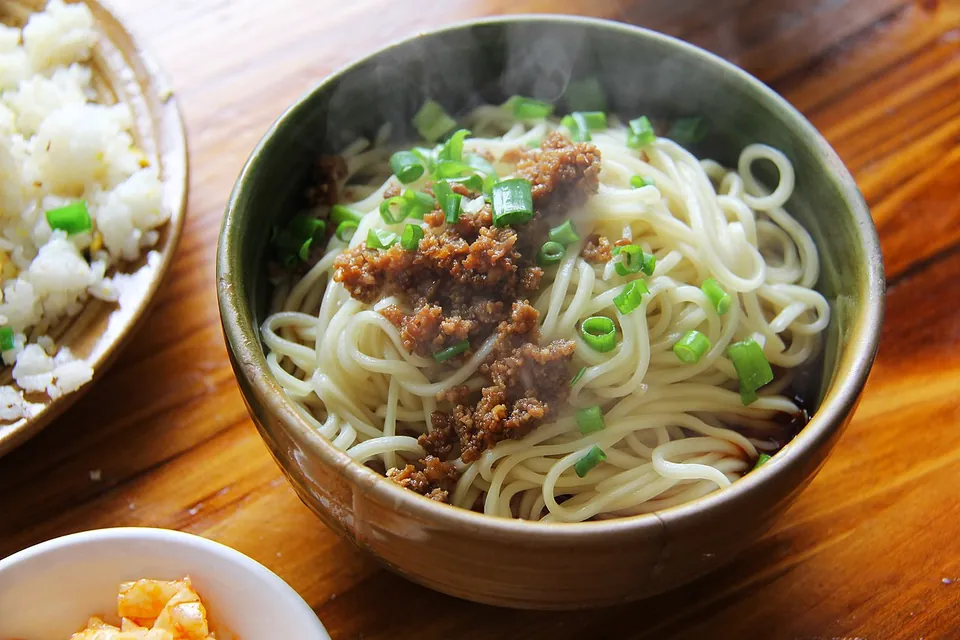 担々麺の実写写真（四川・成都の本来形＝汁なし/汁少なめ（挽肉臊子・青ねぎ、たれは椀底に少量）。日本式汁あり担々麺(#195)ではない。CC0(Pixabay)。）