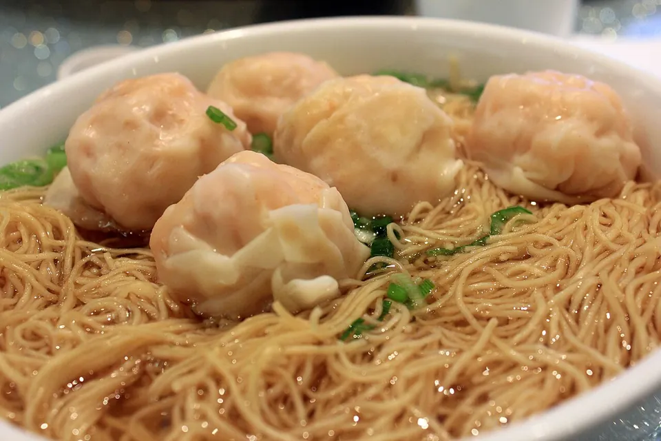 雲呑麺の実写写真（広東式（広州圏）の汁あり雲呑麺の完成皿。スープに細い卵麺と蝦ワンタン（雲呑）＋青葱が入った湯麺形。operator却下理由『汁ありのほうが普通』を満たす差し替え（前回却下は乾撈＝汁なし＋店ロゴ写り込みのHOKO版）。ファイル名は shrimp dumplings だが写るのは細麺上の蝦ワンタン=雲呑麺そのもの）