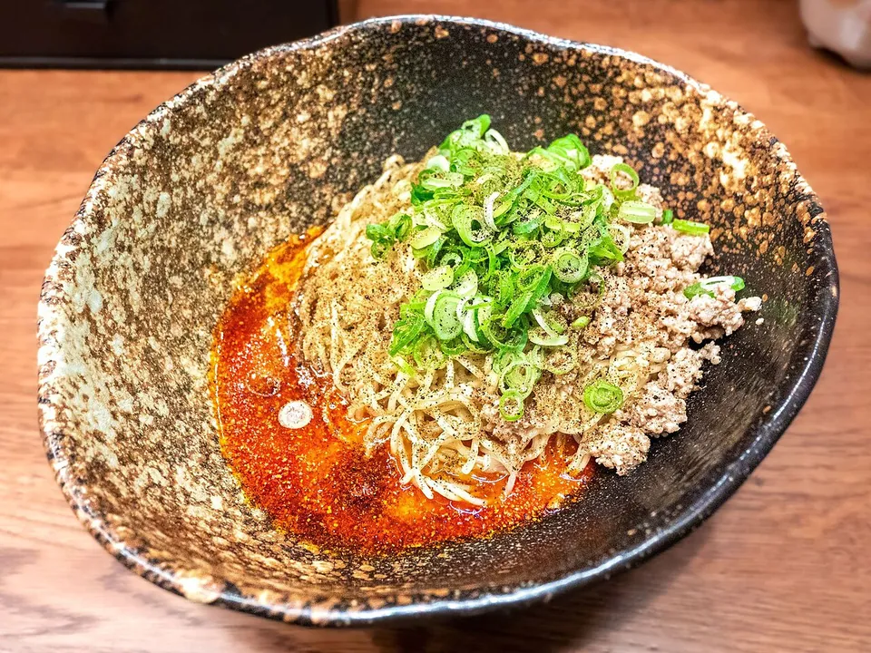広島式汁なし担々麺の実写写真（広島式汁なし担々麺の完成皿=キング軒(広島発祥の汁なし担々麺専門店・本料理の全国化の中心店として起源記録に言及)。芝麻醤を使わず麻辣/辣油の底プール+挽き肉+青葱+花椒/山椒。四川の担々麺(親#194)・汁あり日本式(#195)とは別の地域変種。撮影:くろふね(Jranar)/CC BY 4.0）
