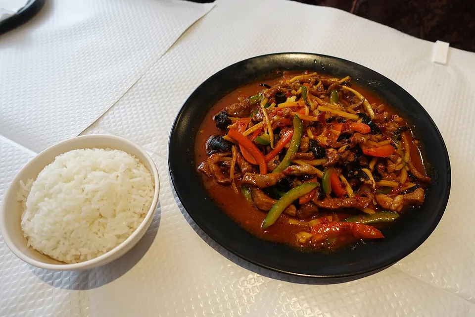 魚香肉絲の実写写真（魚香肉絲（四川料理）。パリの中華料理店提供だが木耳・細切り肉・照りのある紅い魚香ソースが特徴を保持。白飯は別添え（伝統的な単品皿+ライス形式））