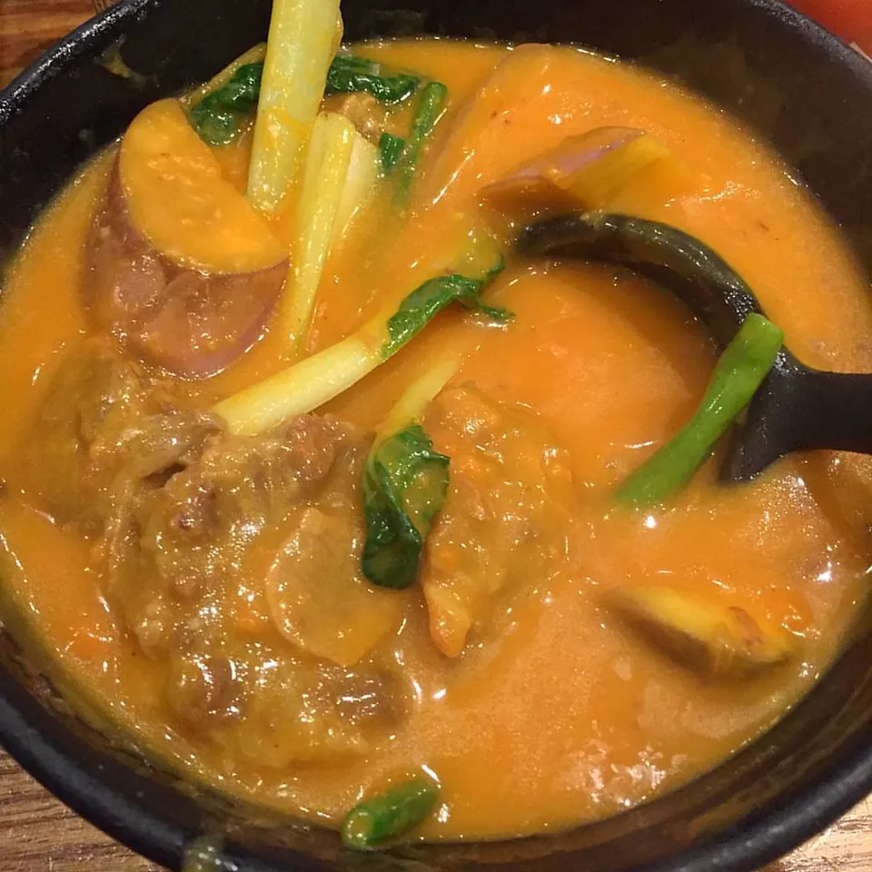 カレカレの実写写真（黒鉢のカレカレ完成皿＝オックステール/牛すね+ナス+インゲン+青菜をピーナッツソースで煮込んだ現行代表形（フィリピン）。1024x1024。前史古層#476カリではなく現行ピーナッツソース形。Flickr由来のためソースはFlickrファイルページ）
