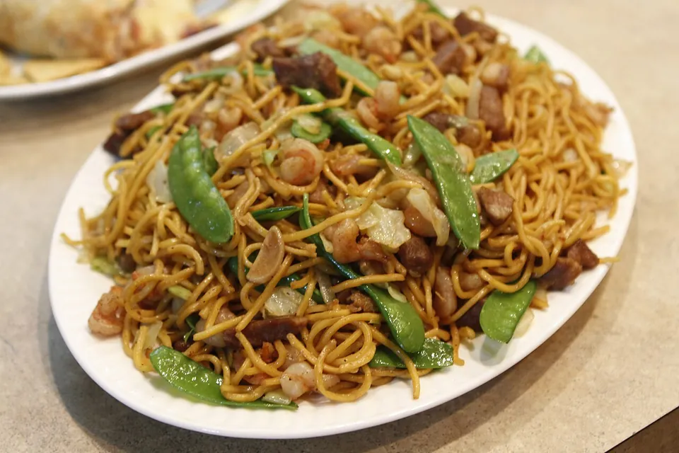 パンシットの実写写真（フィリピン・イロンゴ式パンシット（広東系炒め麺の在地化形）の完成皿。麺・豚肉・エビ・きぬさや等を炒めた代表的な現行形。撮影地はフィリピン。）