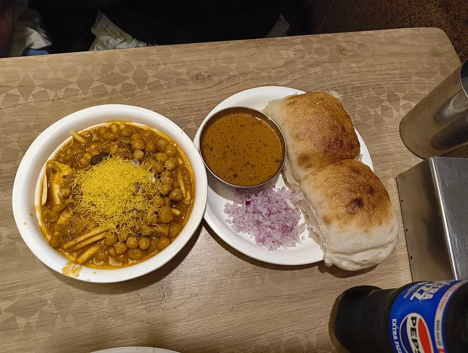 ミサルパヴの実写写真（インド・マハラシュトラのミサルパヴ。発芽豆/ひよこ豆のスパイシーカレー（sev載せ）＋タリ（辛いグレイビー）＋刻み玉ねぎ＋パヴ2個の標準的な供膳。現行形の完成皿。撮影者Sakurakat・CC0）