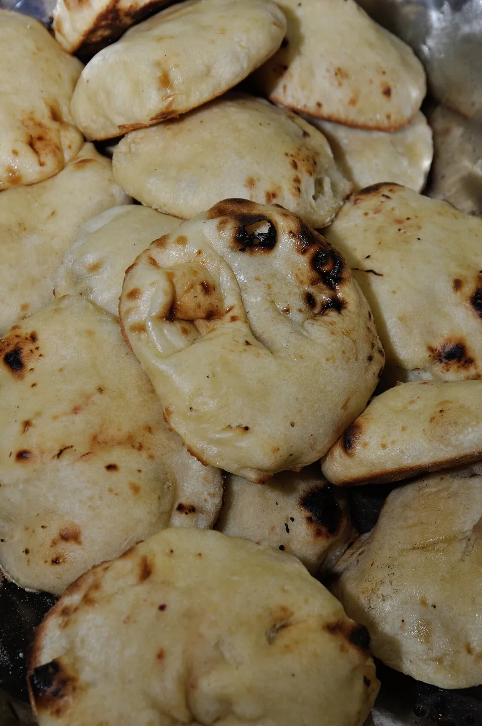 クルチャの実写写真（焼き上げた円盤状の発酵パン＝クルチャ本体（ペルシア語 kulcheh=円盤状発酵パンの語義に整合する基本形）。撮影はコルカタ。パンジャブ/アムリトサリ式の詰め物入り現行形とは別の素焼き基本形＝operatorは地域/変種の適合を要判断）