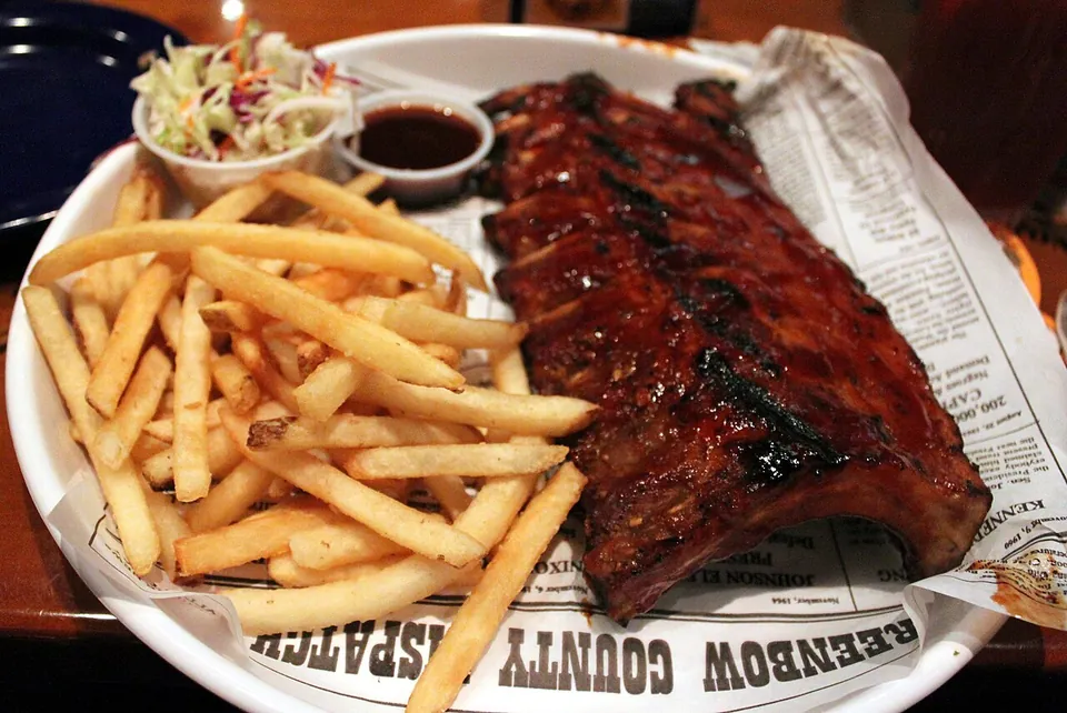 BBQリブ（バーベキュー・リブ）の実写写真（米国南部（Dixie）式ベビーバックリブの完成皿。BBQソース塗布・スモーク済み。現行型の南部BBQリブを代表する構図）