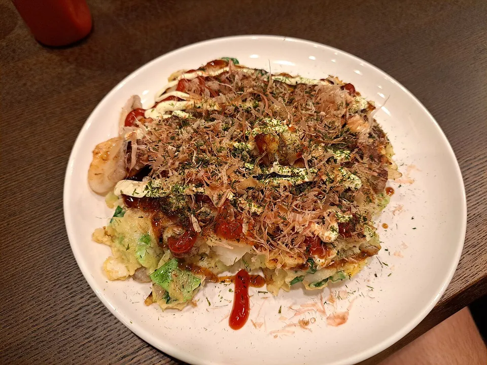 お好み焼きの実写写真（関西風（キャベツを生地に混ぜ込む方式）の完成皿。構造データの成立史はキャベツを主体に生地へ混ぜる様式(関西風)を記述しており、広島風(重ね焼き)ではなくこちらを選定）