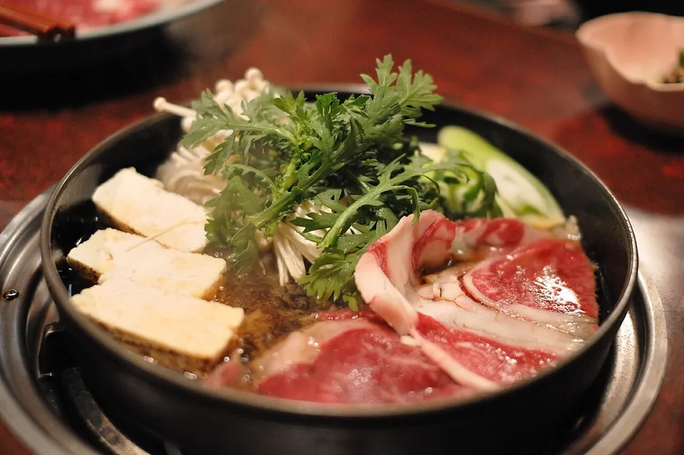 すき焼きの実写写真（牛肉・豆腐・春菊・えのきの関東風すき焼き鍋・具材が見える完成前盛り付け）